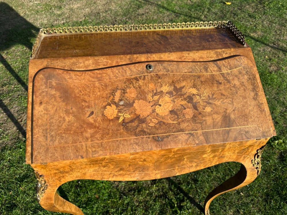 A 19th-century French bureau de dame crafted with floral marquetry inlay, slender cabriole legs, decorative brass corner mounts, and a brass gallery along the top. View II