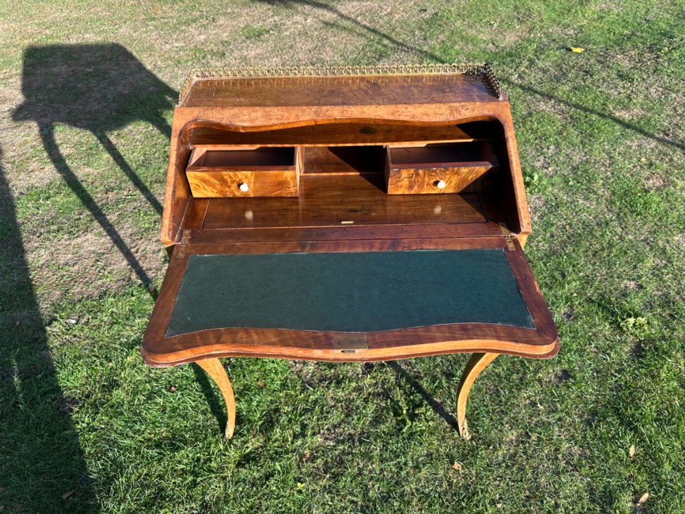 A 19th-century French bureau de dame crafted with floral marquetry inlay, slender cabriole legs, decorative brass corner mounts, and a brass gallery along the top. View III