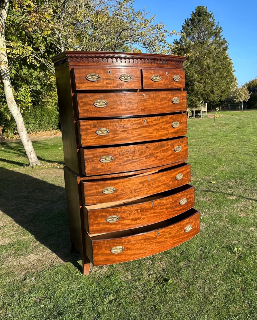 A George III bowfront mahogany chest on chest featuring a decorative top cornice, oval brass handles, and two upper and five lower drawers. View III