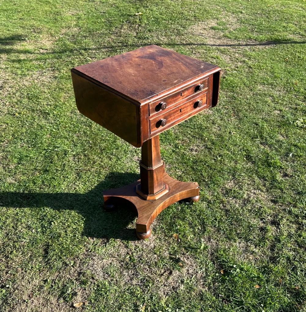 A 19th-century mahogany Pembroke table featuring two drawers, two folding drop leaves, a central pedestal column, and a shaped quadform base.