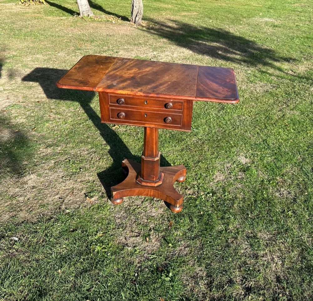 A 19th-century mahogany Pembroke table featuring two drawers, two folding drop leaves, a central pedestal column, and a shaped quadform base. View IV
