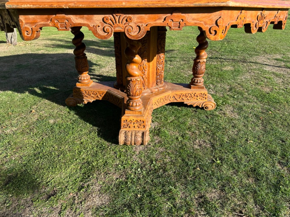 An octagonal warm oak table featuring ebonised wood stringing, a central inlaid rosette, carved apron detail, and a heavy carved pedestal base. View II