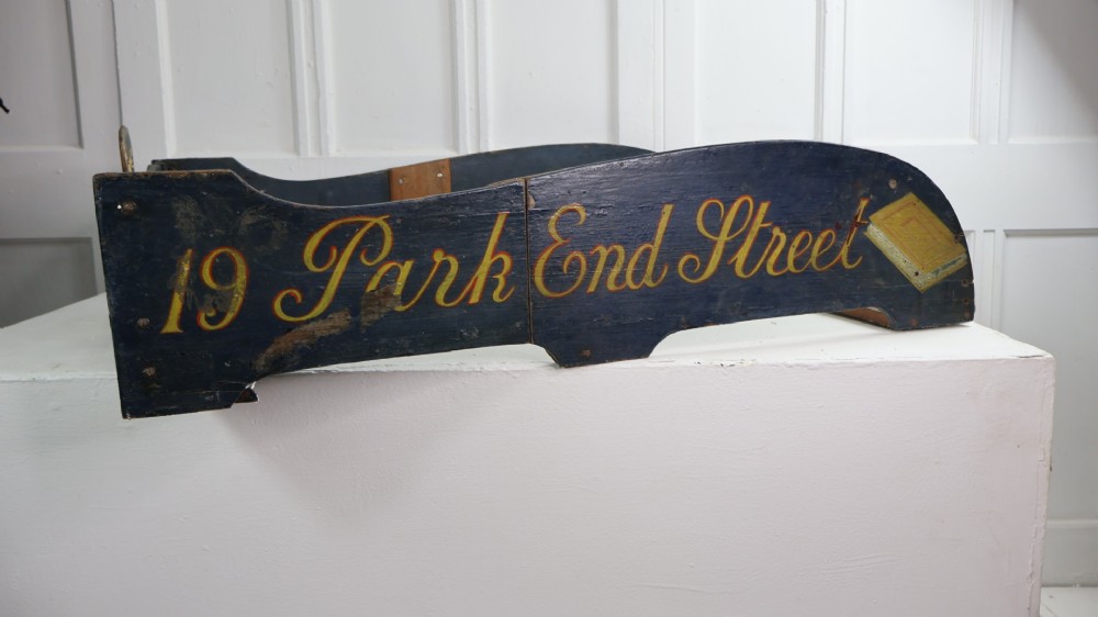 A pair of 19th-century dark blue painted wooden cart sides featuring hand-painted gold lettering reading 19 Park End Street alongside a book icon.