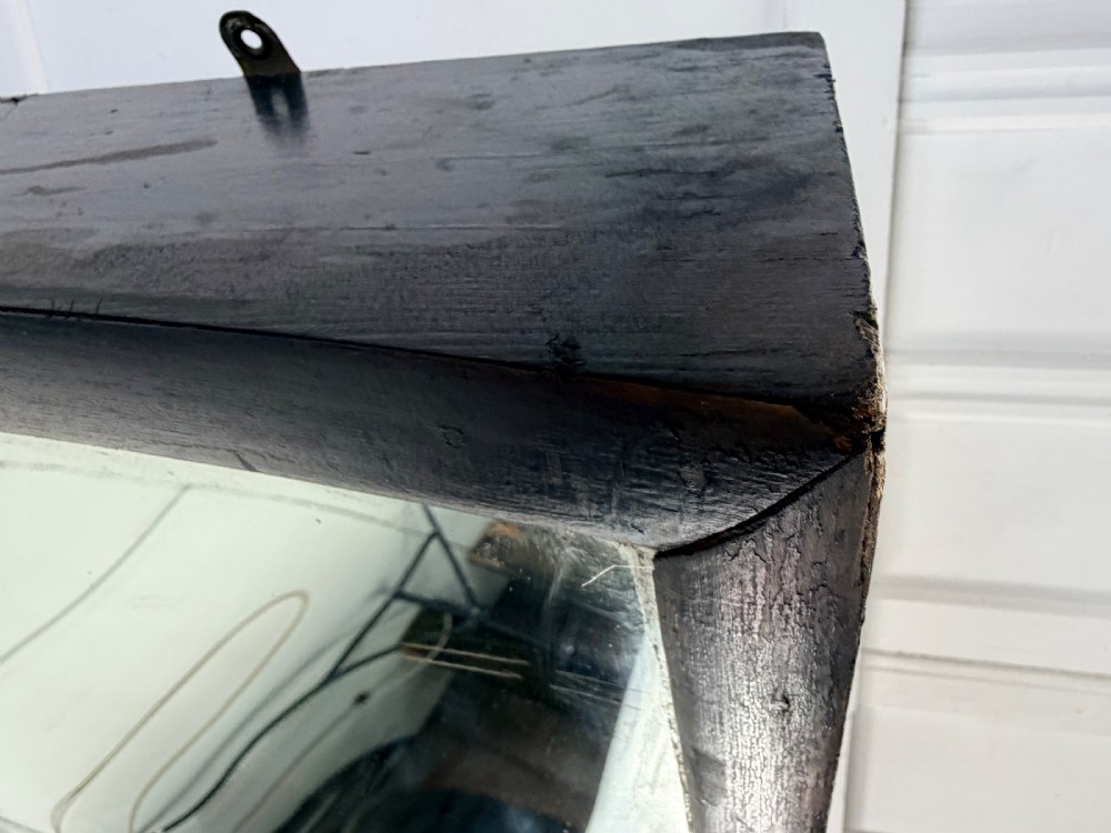 A tall, rectangular 19th-century fairground distortion mirror with curved glass housed inside a simple dark painted wooden frame. View XI