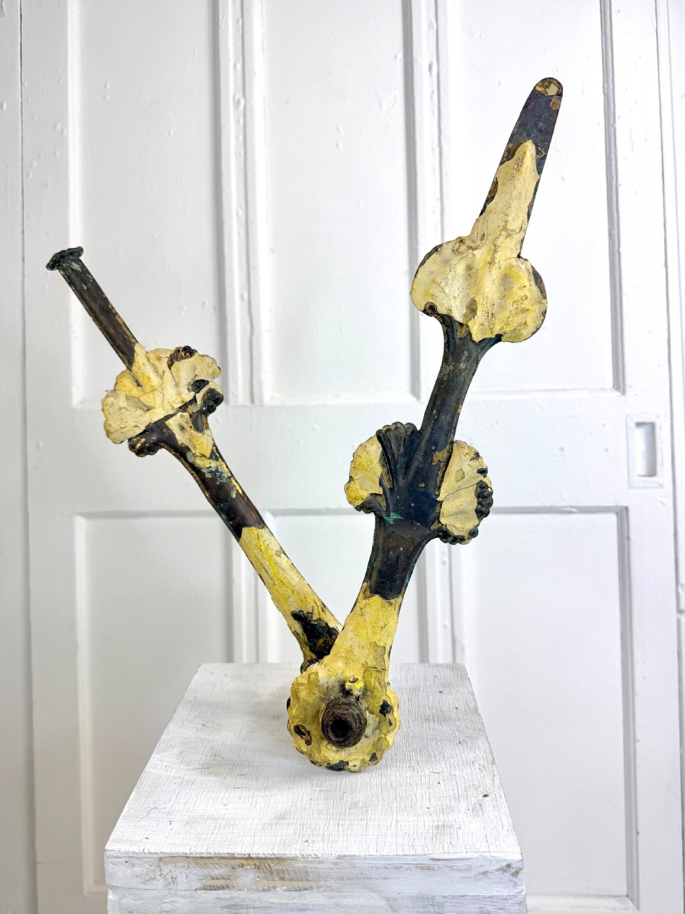 A pair of large Georgian copper clock hands displaying distressed yellow painted surfaces and dark oxidised metal.
