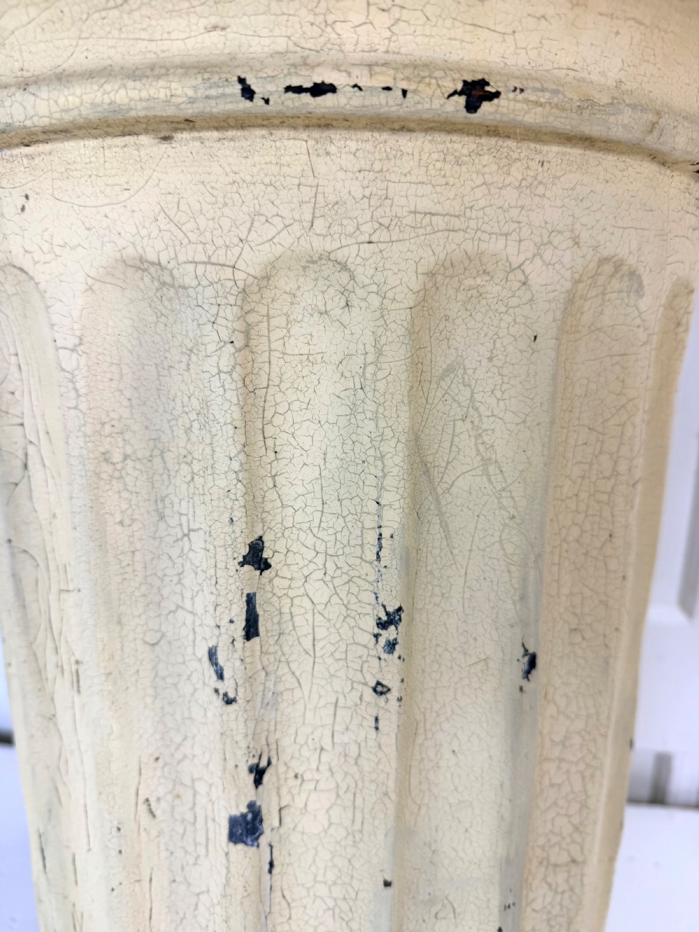A nineteenth-century fluted terracotta display column with a distressed cream painted finish and a circular capital and base. View II