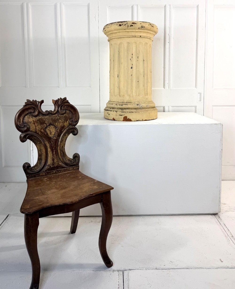 A nineteenth-century fluted terracotta display column with a distressed cream painted finish and a circular capital and base. View V