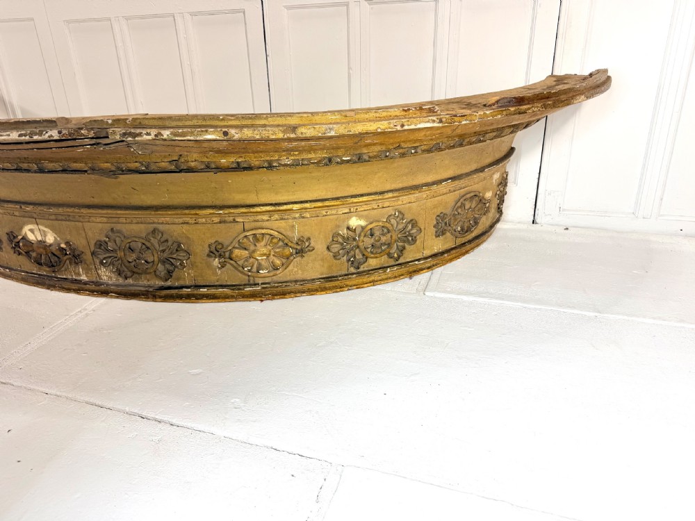 A large curved 19th-century carved timber and gilded window pelmet decorated with floral rosettes and egg-and-dart moulding. View II