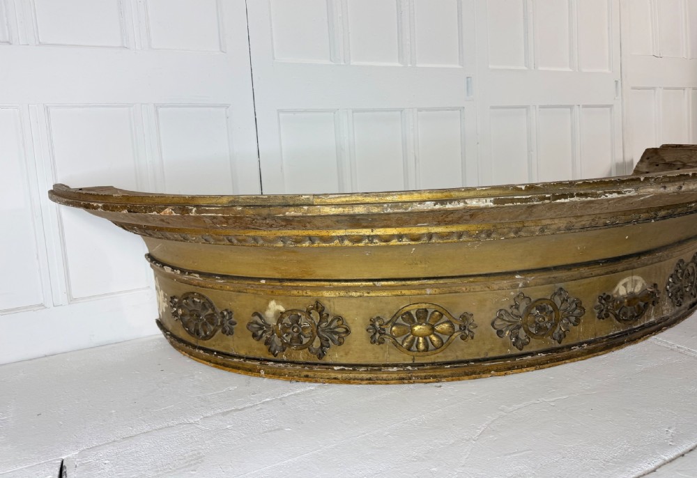 A large curved 19th-century carved timber and gilded window pelmet decorated with floral rosettes and egg-and-dart moulding. View V