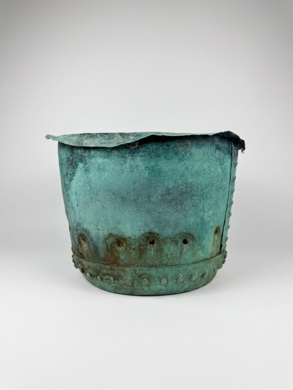 A 19th-century riveted copper garden planter pot featuring a heavily weathered verdigris patina and a perforated lower band.