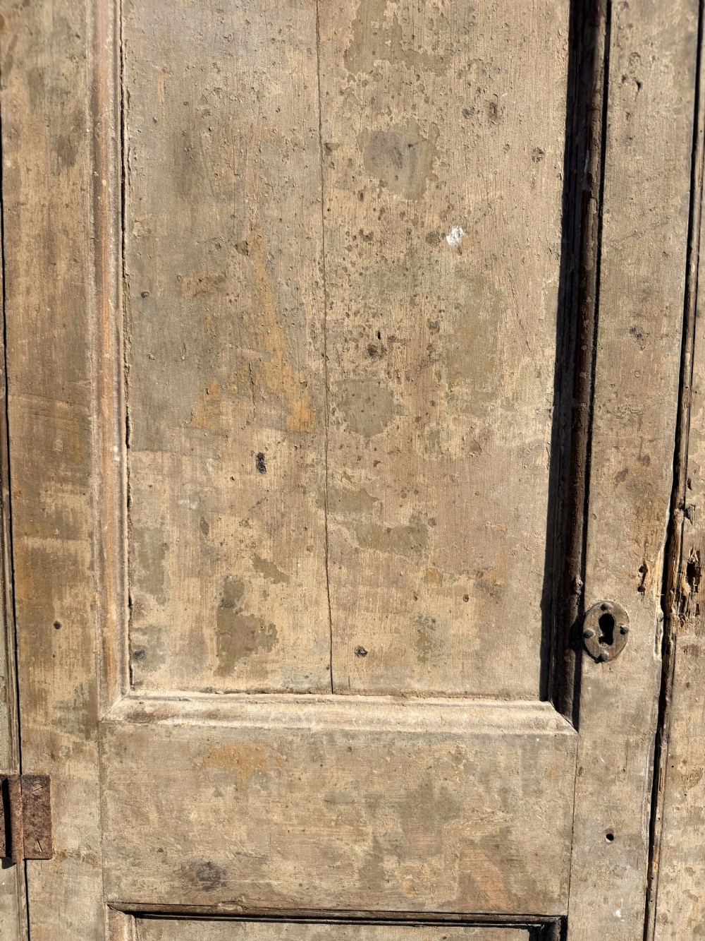 A tall, narrow Georgian pine gun cupboard featuring a single door with two panel inserts and visible iron hinges. View III