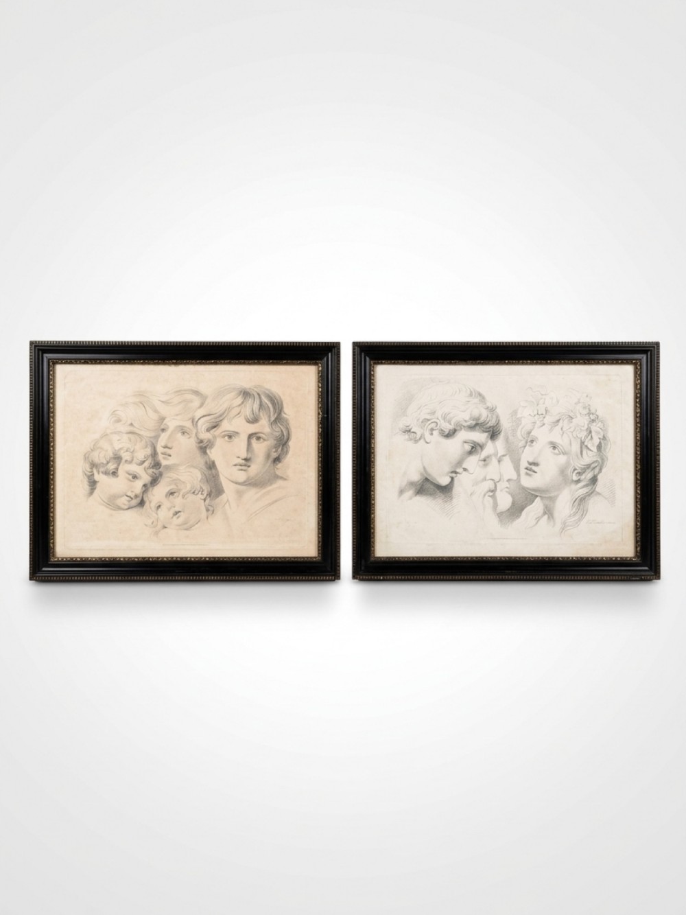 A pair of 19th-century framed monochrome etchings depicting classical human head and profile studies.