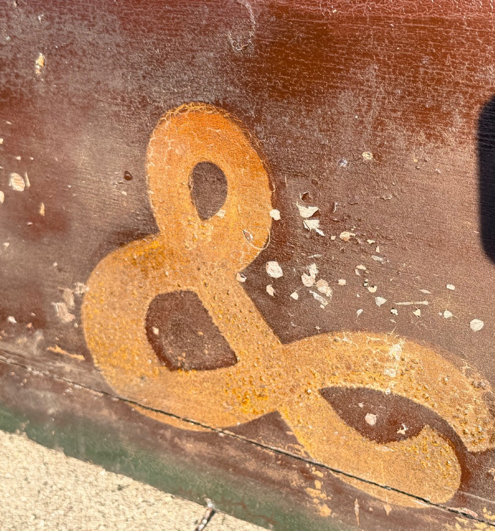 A long, narrow nineteenth-century wooden trade sign featuring a dark brown background with gilded serif lettering reading CARPENTER & CO. View IV