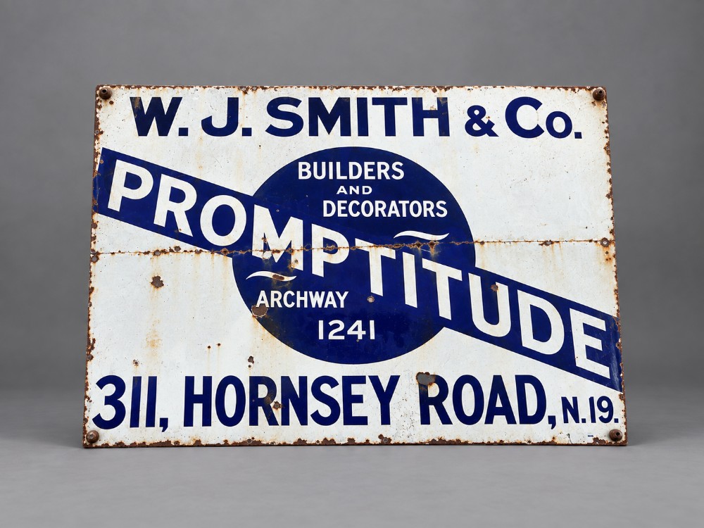 A large rectangular white vitreous enamel sign with bold dark blue typography detailing W. J. Smith & Co. Builders and Decorators of Hornsey Road.