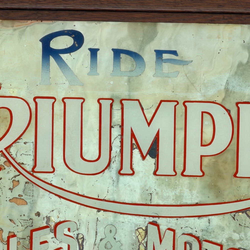 A rectangular 1920s Triumph Cycles and Motors advertising mirror featuring foxed glass and a dark oak timber frame. View IV