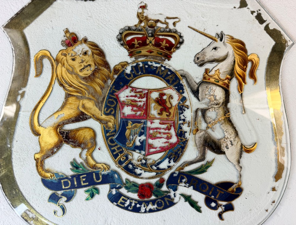 An Edwardian heraldic shield-shaped plaque featuring the gilded British Royal Coat of Arms with a lion, unicorn, and mottoes against a painted off-white background with distressed gold trim. View III