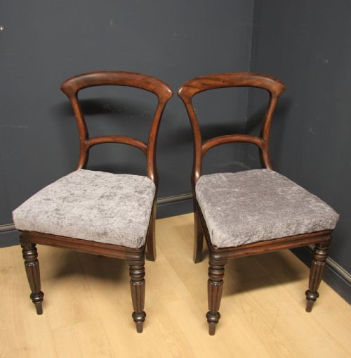 fig 1. A pair of antique William IV mahogany side chairs featuring turned front legs, curved top rails, and grey upholstered seats.