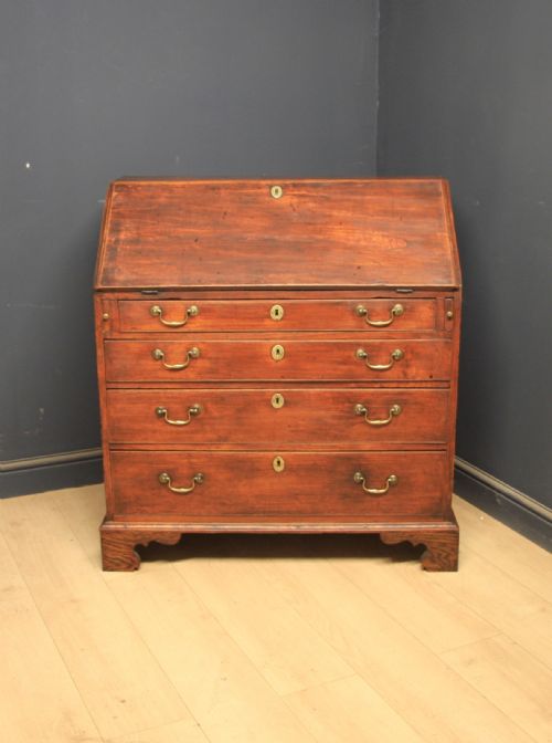 fig 1. A Georgian elm writing bureau featuring a sloped fall-front flap above four long graduated drawers fitted with brass swan-neck handles, supported on bracket feet.