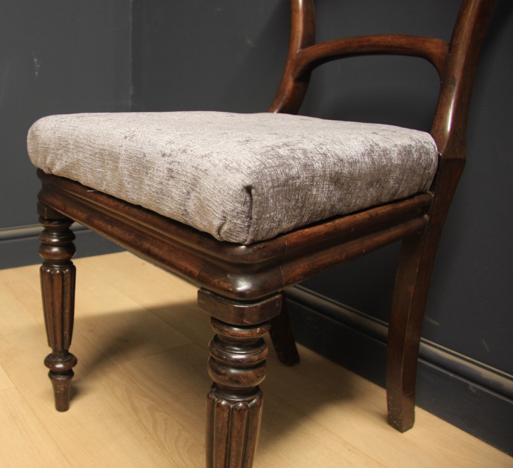A pair of antique William IV mahogany side chairs featuring turned front legs, curved top rails, and grey upholstered seats. View IV