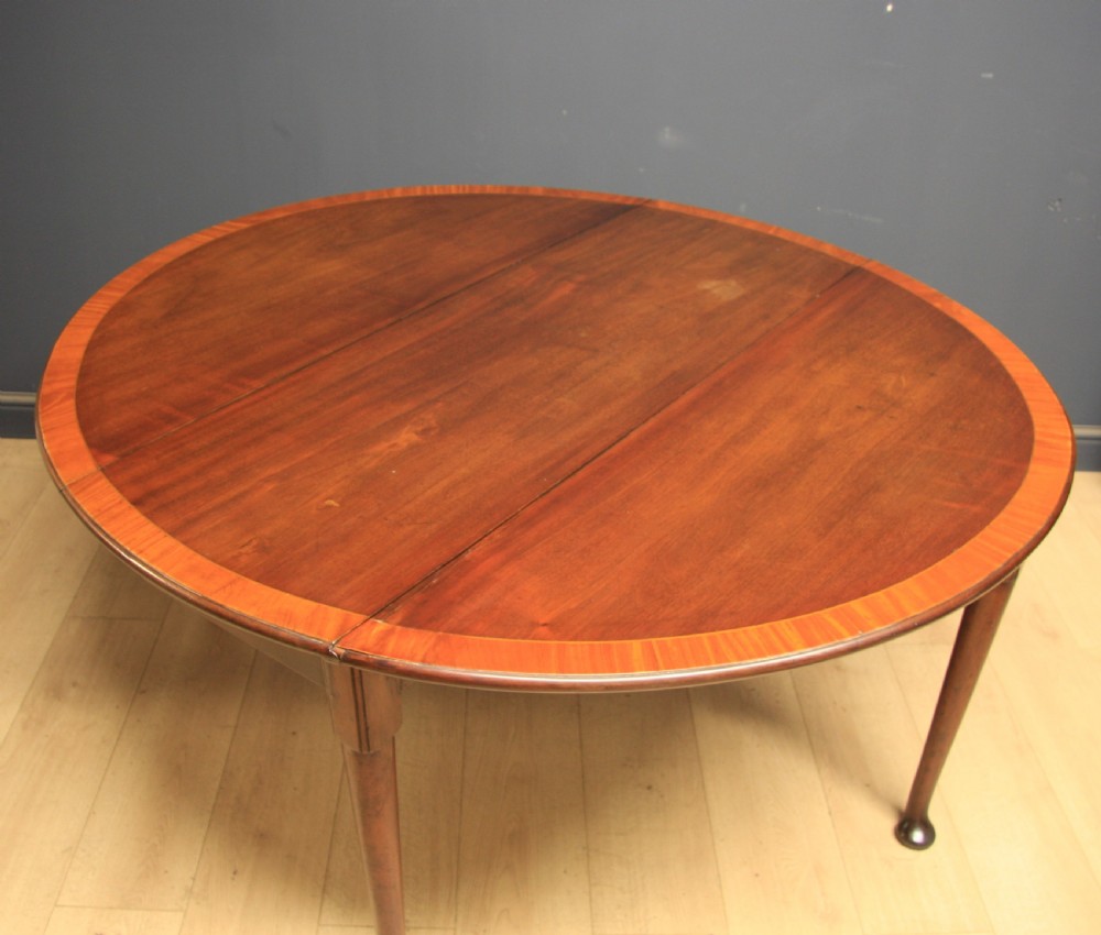 A Georgian mahogany drop-leaf dining table featuring crossbanded inlay borders, tapered legs, and pad feet. View III