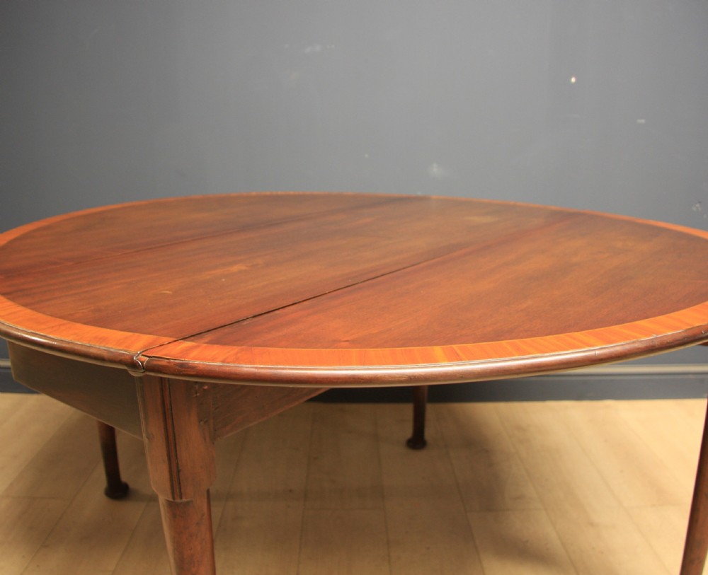 A Georgian mahogany drop-leaf dining table featuring crossbanded inlay borders, tapered legs, and pad feet. View VI