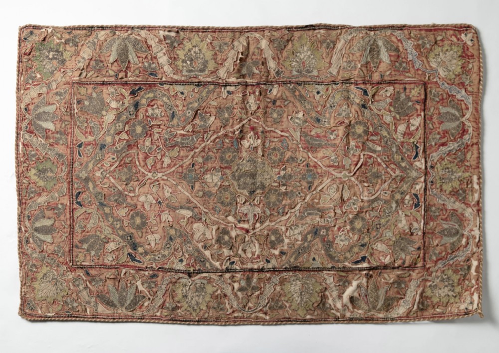 An 18th-century rectangular embroidered textile panel featuring a central lozenge motif surrounded by dense floral arabesques in muted terracotta and sage tones.