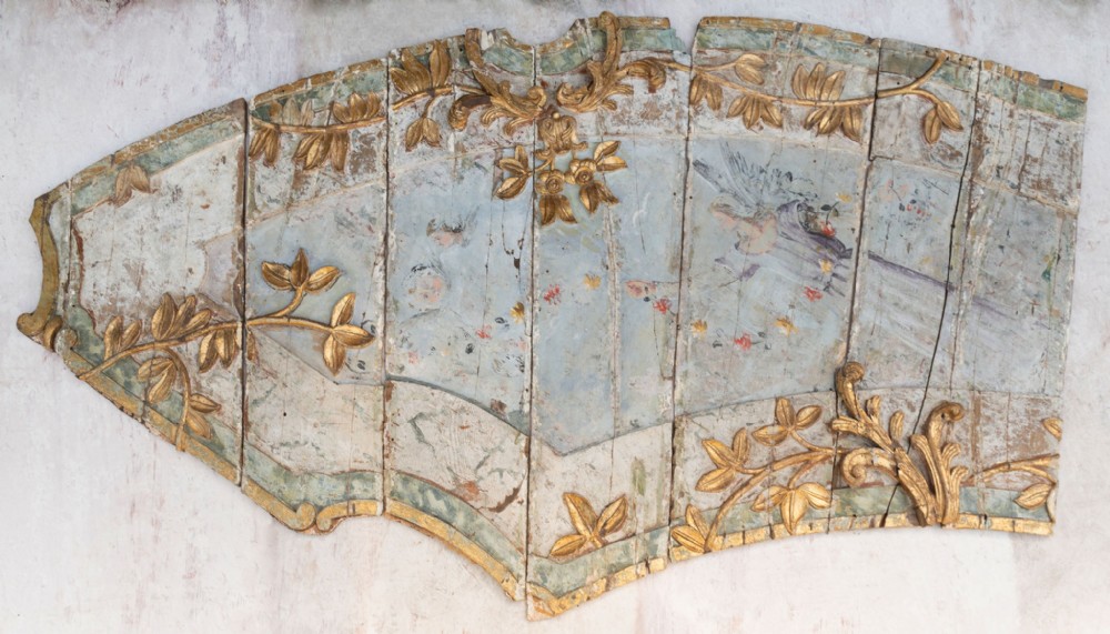 A curved antique Italian timber panel featuring pale blue polychrome paintwork and raised carved giltwood foliage motifs.