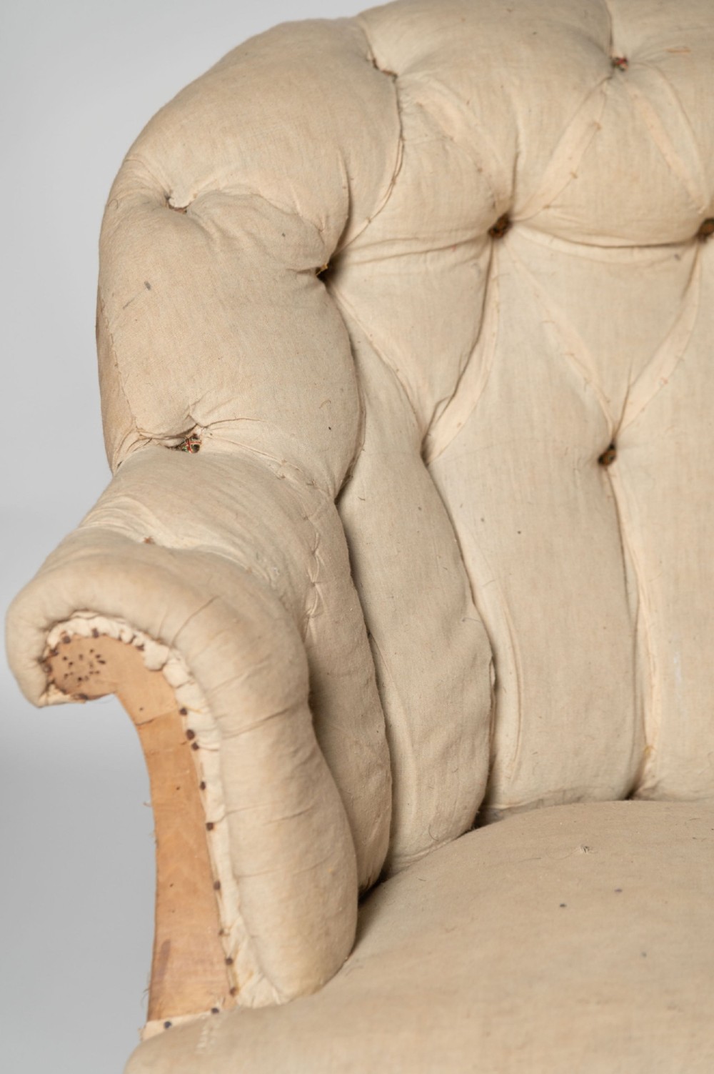 An antique French sofa upholstered in cream calico fabric with deep button tufting along the backrest and dark cabriole front legs. View III