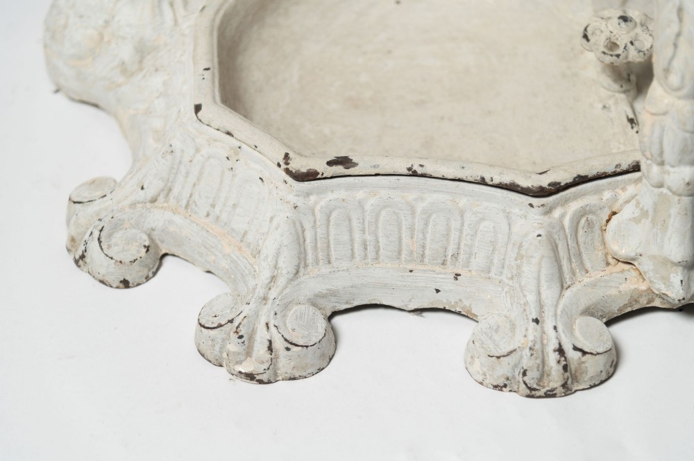 An antique white painted cast iron hall stand featuring intricate scrollwork, integrated coat hooks, a small central mirror, and a base drip tray. View XI