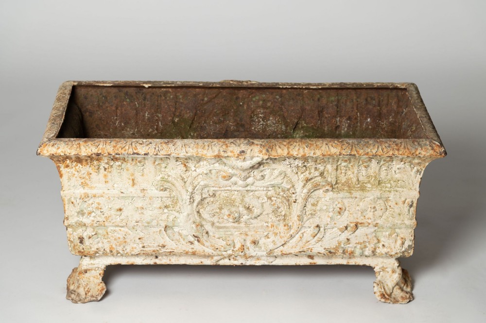 A 19th-century French rectangular cast iron planter featuring distressed off-white paint, detailed acanthus leaf relief, and short paw feet. View VI