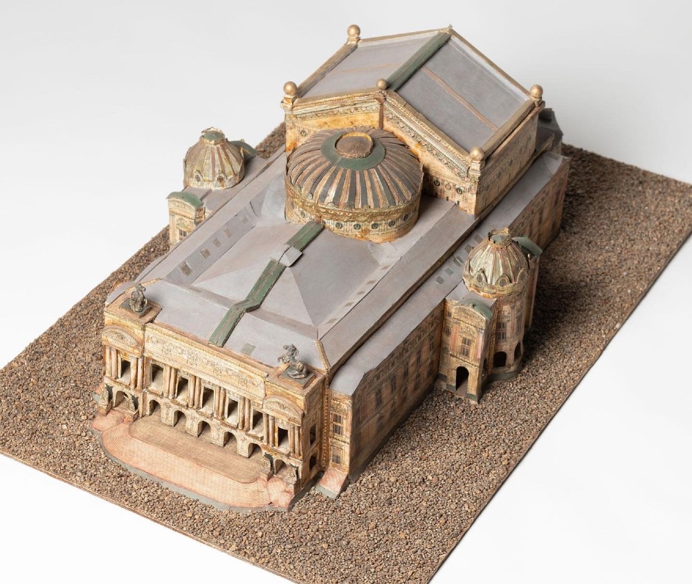A detailed scale paper model of the Paris Opera House featuring a central dome, classical arcade facade, and miniature roof statuary mounted on a textured gravel base. View IX