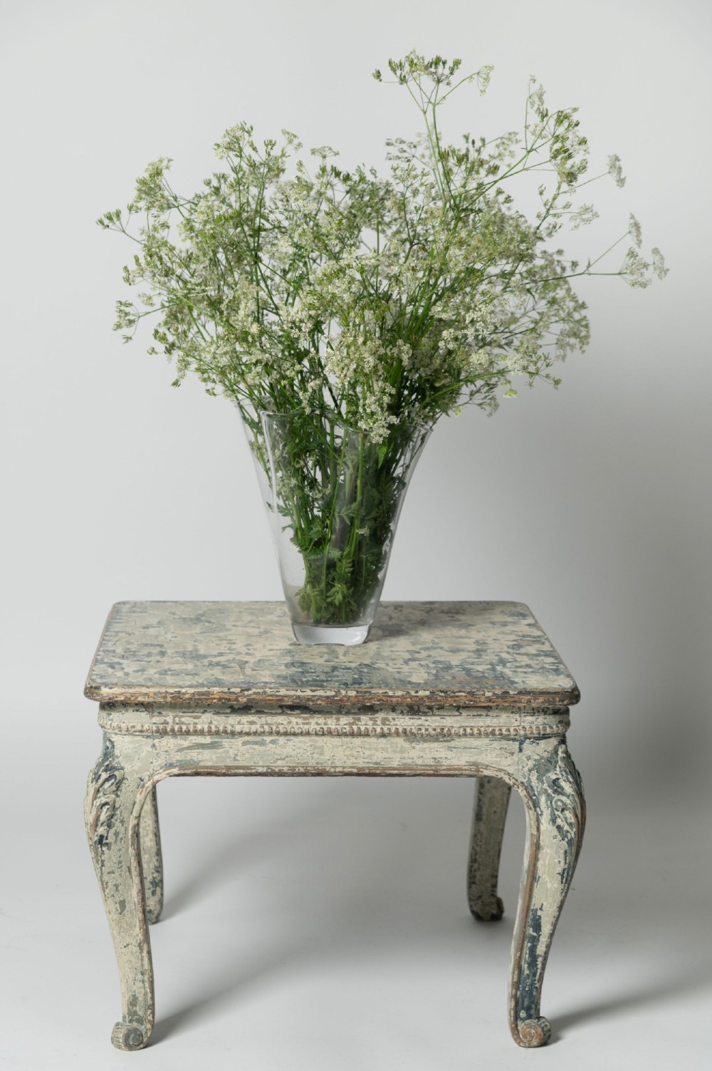 A square antique French side table featuring weathered grey and blue paint, carved cabriole legs, and bead moulding along the apron. View III