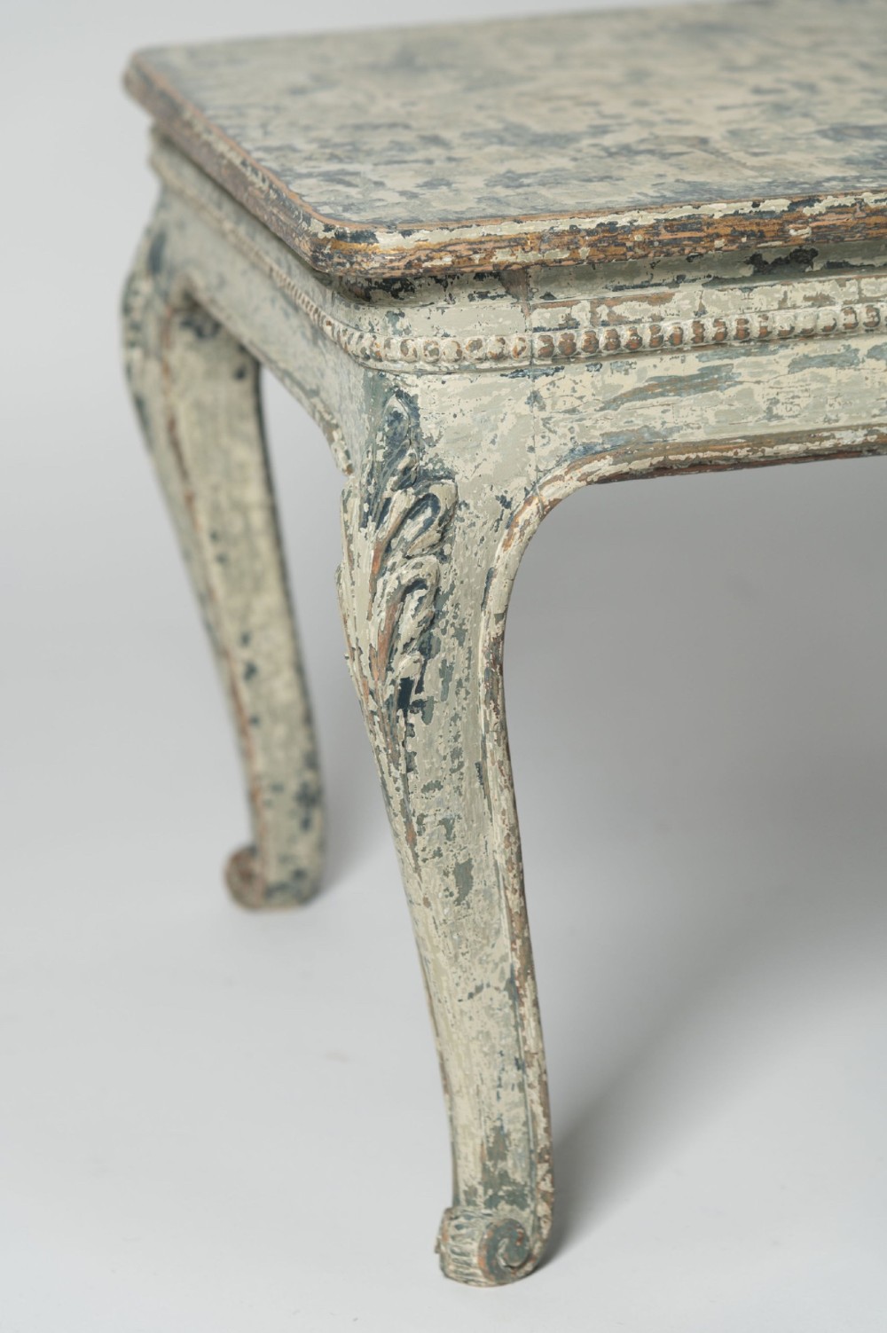 A square antique French side table featuring weathered grey and blue paint, carved cabriole legs, and bead moulding along the apron. View V