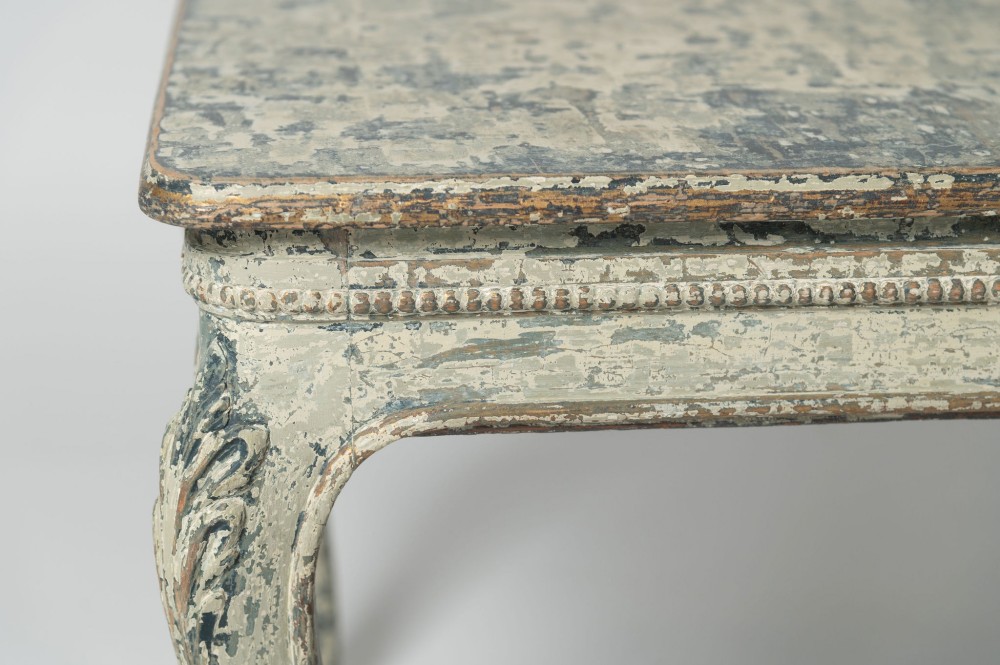 A square antique French side table featuring weathered grey and blue paint, carved cabriole legs, and bead moulding along the apron. View IX