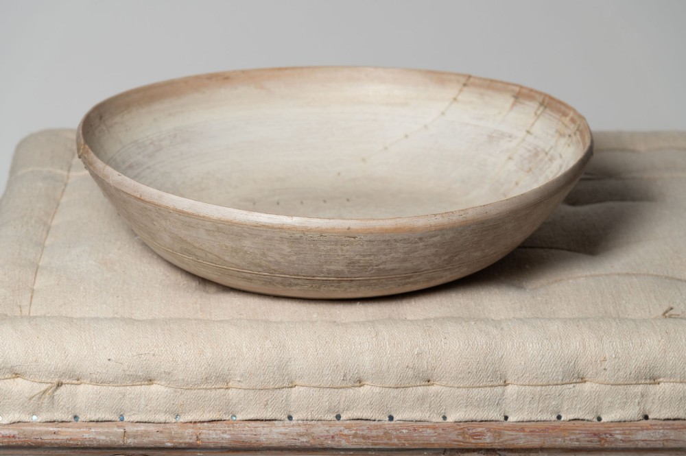 A wide, shallow antique Swedish wooden dairy bowl with a pale, scrubbed timber finish and subtle turned rim lines. View II