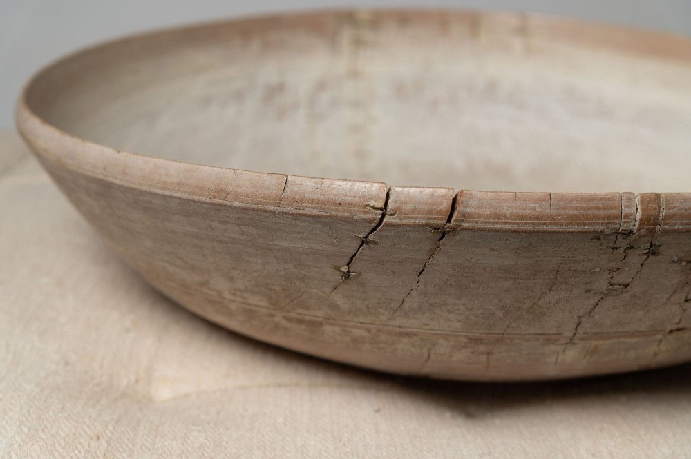 A wide, shallow antique Swedish wooden dairy bowl with a pale, scrubbed timber finish and subtle turned rim lines. View VIII