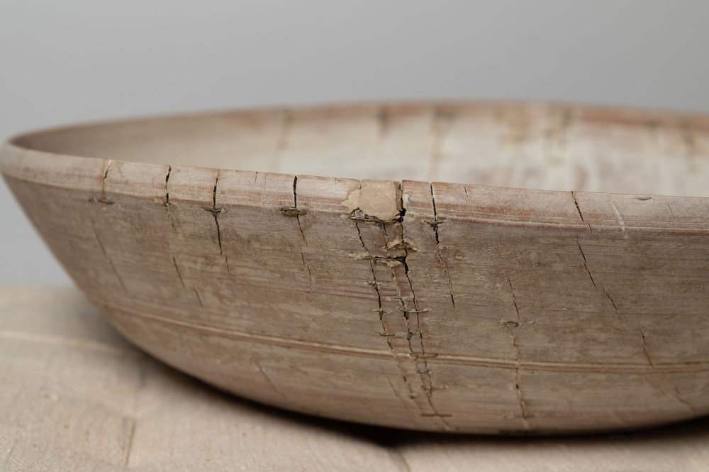 A wide, shallow antique Swedish wooden dairy bowl with a pale, scrubbed timber finish and subtle turned rim lines. View IX
