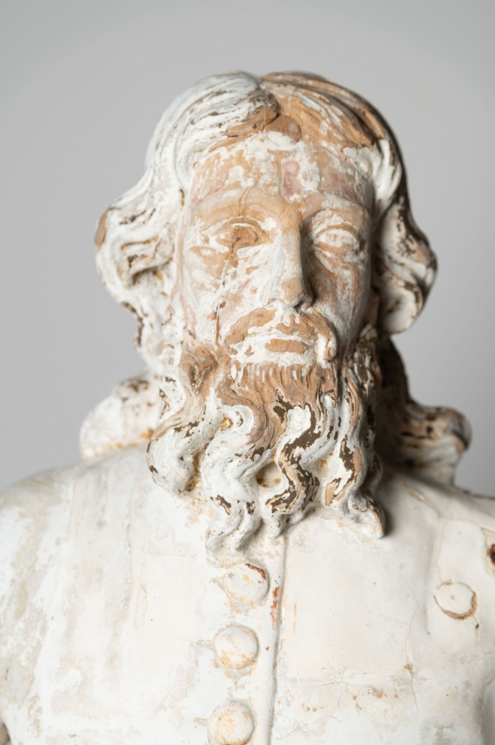A standing antique hand-carved wooden statue of a nobleman in seventeenth-century attire with a distressed white painted finish. View II