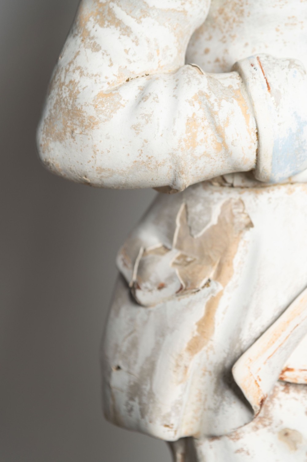 A standing antique hand-carved wooden statue of a nobleman in seventeenth-century attire with a distressed white painted finish. View V