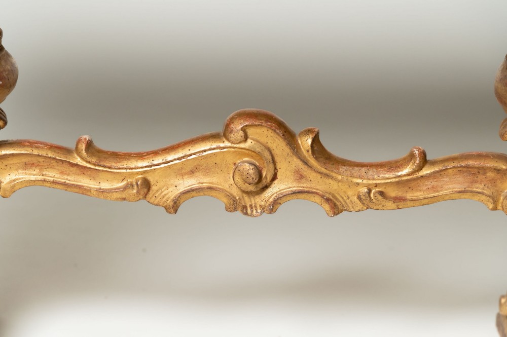A low rectangular Italian giltwood coffee table featuring carved baroque supports, a scroll stretcher, and an inset floral textile top with a gilded frame. View VII