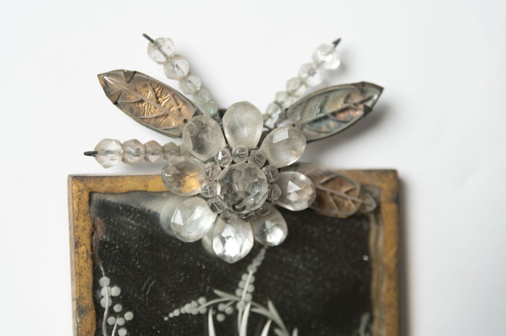A pair of French gilt metal wall sconces featuring verre eglomise panels depicting birds, with floral crystal cresting and two scroll arms. View VI