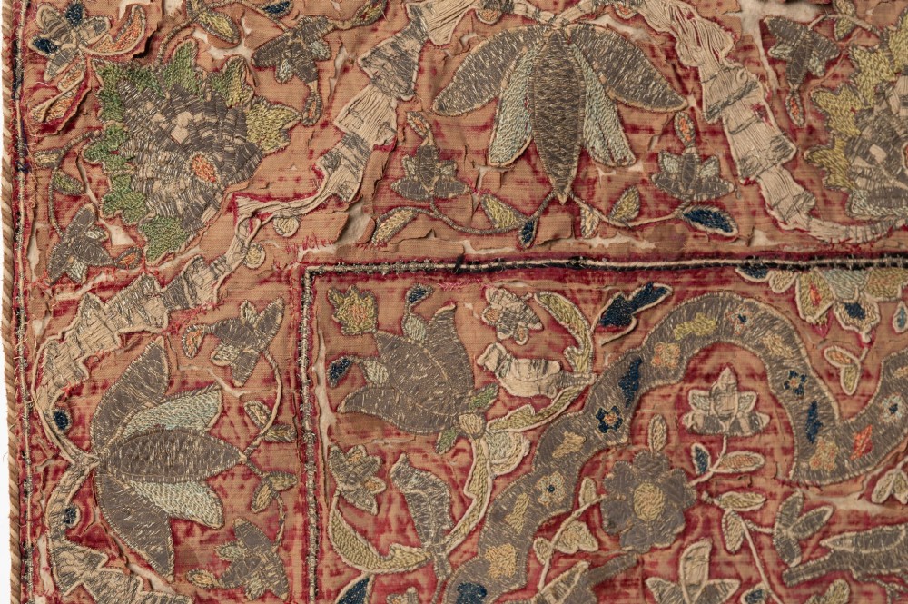A rectangular 18th-century hand-embroidered textile featuring a central diamond medallion with floral arabesques and border patterns in shades of muted pink, sage green, and cream. View II