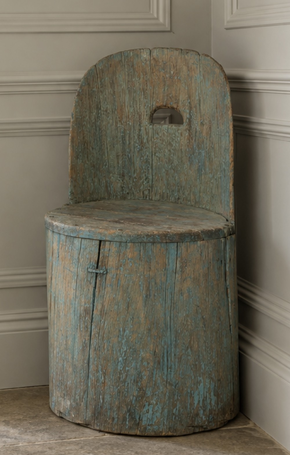 An antique Swedish dugout chair carved from a single hollowed log with weathered blue paint and a rounded back rest.