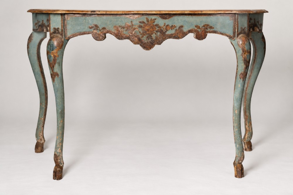 An 18th-century Venetian painted console table with cabriole legs, a contoured apron, and distressed light blue paint with floral scrollwork.