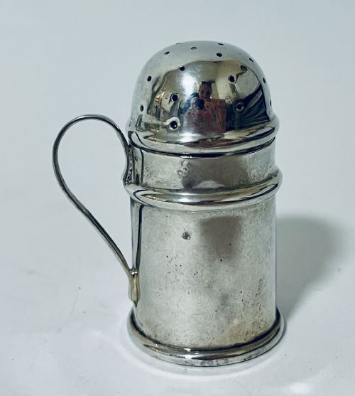 fig 1. A cylindrical silver pepper shaker featuring a domed perforated top, raised horizontal mouldings, and a flat circular base.