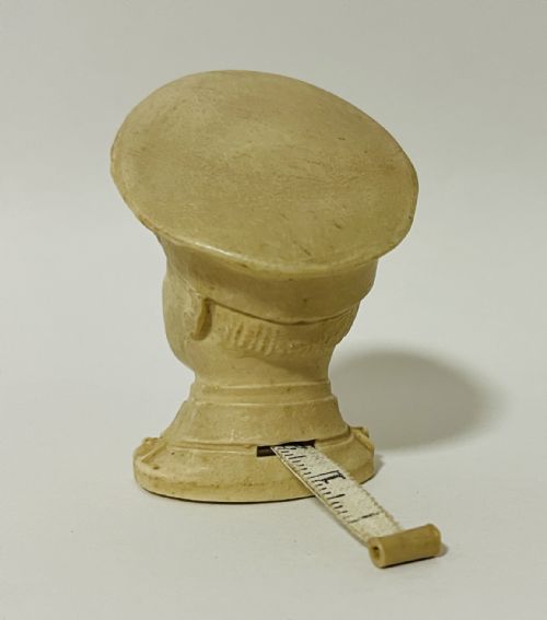 fig 1. A cream-coloured moulded celluloid novelty tape measure depicting a military bust of King Edward VIII.