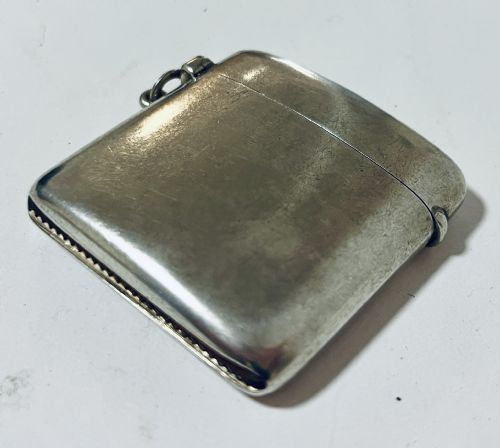 fig 1. An antique plain sterling silver vesta case featuring rounded corners, a hinged lid, and a small side suspension loop.
