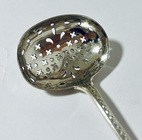 fig 2. An antique Georgian silver sugar sifter spoon featuring a pierced bowl and an engraved handle.