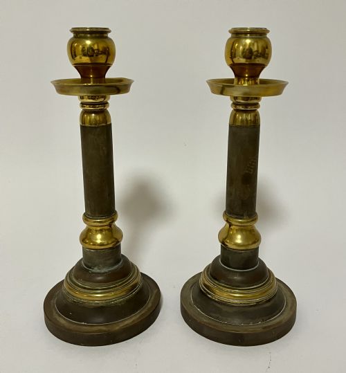 fig 1. A pair of Edwardian turned brass candlesticks featuring circular stepped bases and alternating polished and patinated dark brass sections.