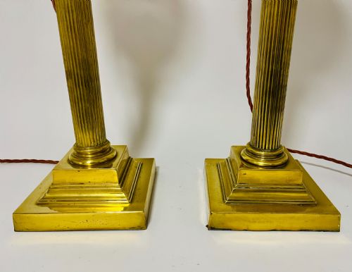 fig 1. A pair of brass Corinthian column table lamps featuring stepped square plinths, fluted columns, acanthus capitals, and cut glass reservoirs.